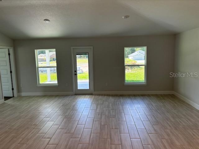 spare room featuring baseboards and wood finished floors