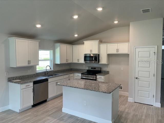 kitchen featuring white cabinetry, a sink, visible vents, stainless steel appliances, and a center island