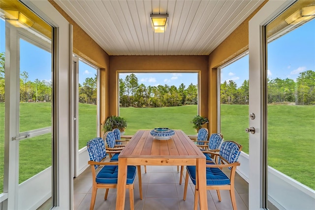 sunroom / solarium featuring a healthy amount of sunlight and wood ceiling