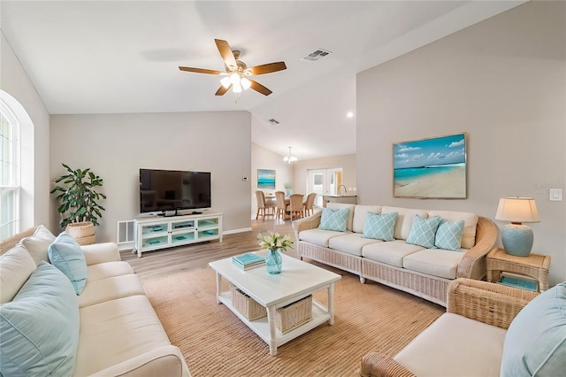 living room with ceiling fan, plenty of natural light, lofted ceiling, and hardwood / wood-style flooring