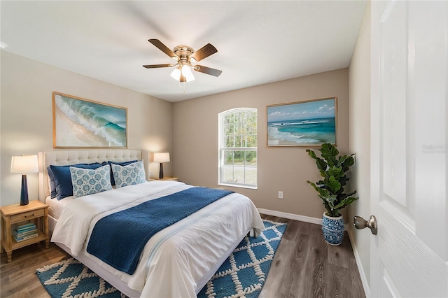 bedroom featuring baseboards, dark wood-style flooring, and a ceiling fan