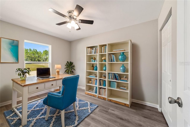 office space with baseboards, ceiling fan, and wood finished floors