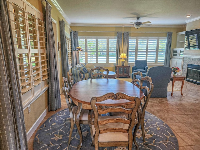 dining area featuring tile patterned floors, ceiling fan, a wealth of natural light, and ornamental molding