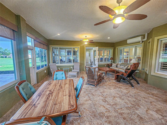 sunroom / solarium with a wall mounted air conditioner and ceiling fan