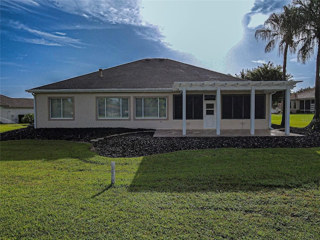 rear view of property featuring a pergola, a lawn, and a patio