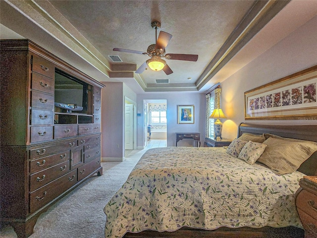 bedroom featuring a tray ceiling, a textured ceiling, ceiling fan, and carpet floors