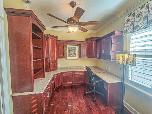 office space featuring dark wood-type flooring, built in desk, ceiling fan, and a wealth of natural light