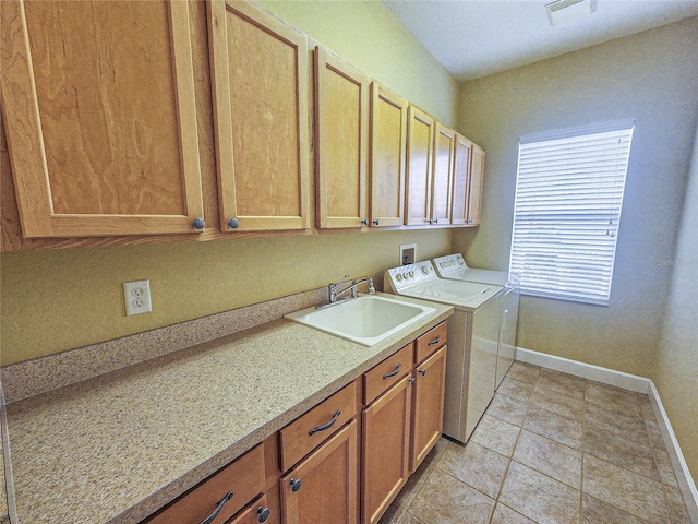 laundry room with light tile patterned floors, washing machine and clothes dryer, cabinets, and sink