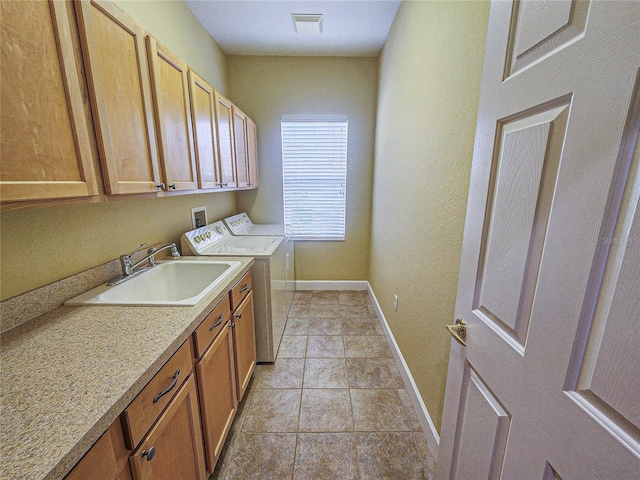 laundry area featuring washer and dryer, cabinets, sink, and light tile patterned flooring