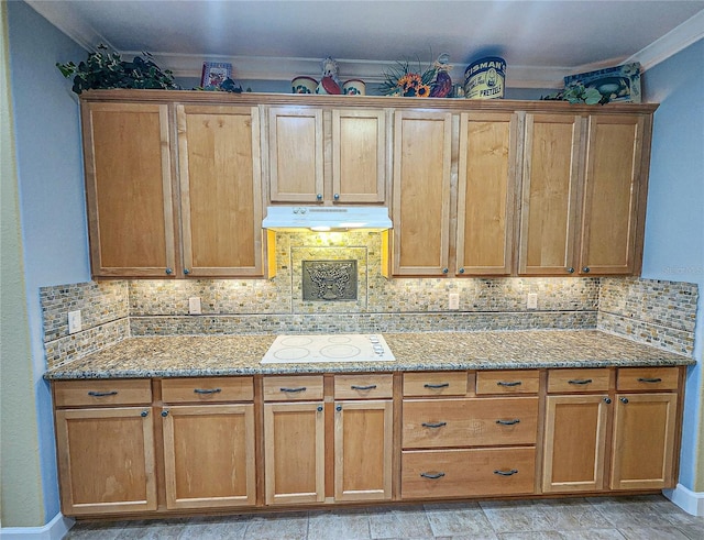 kitchen featuring light stone counters, white electric cooktop, and decorative backsplash