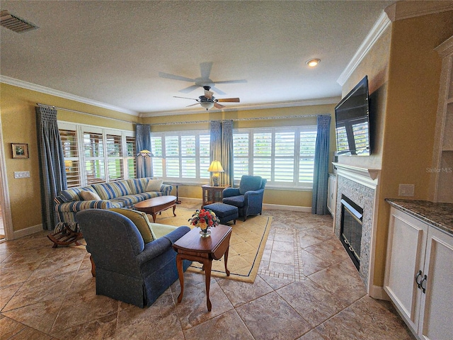 living room with crown molding, a textured ceiling, ceiling fan, and a stone fireplace