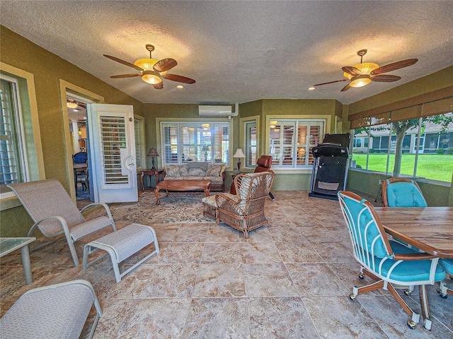 interior space with ceiling fan, an AC wall unit, and a healthy amount of sunlight