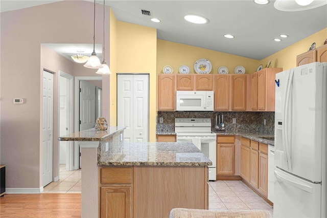 kitchen featuring light tile patterned flooring, white appliances, a kitchen island, decorative light fixtures, and vaulted ceiling