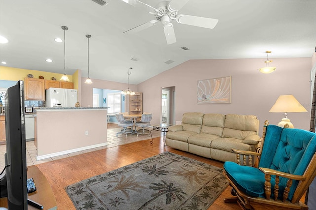 living room with ceiling fan, light wood-type flooring, and vaulted ceiling