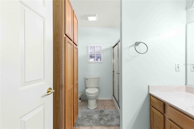 bathroom featuring tile patterned flooring, an enclosed shower, vanity, and toilet