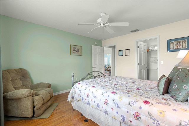 bedroom featuring wood-type flooring, a spacious closet, ceiling fan, and a closet