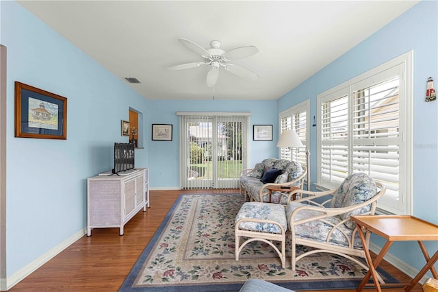 living room with ceiling fan and dark wood-type flooring