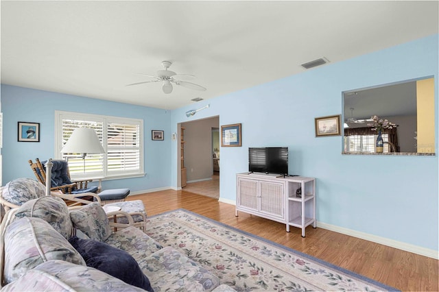 living room featuring wood-type flooring and ceiling fan