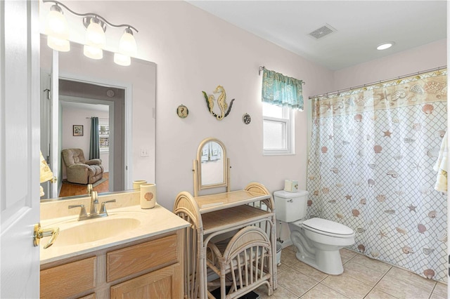 bathroom featuring curtained shower, tile patterned flooring, vanity, and toilet