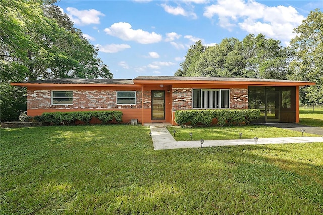 ranch-style house featuring a sunroom and a front lawn