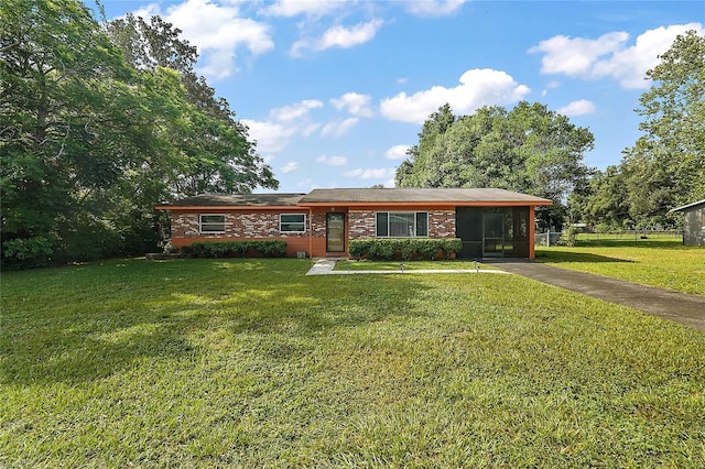 single story home featuring a front yard and a sunroom