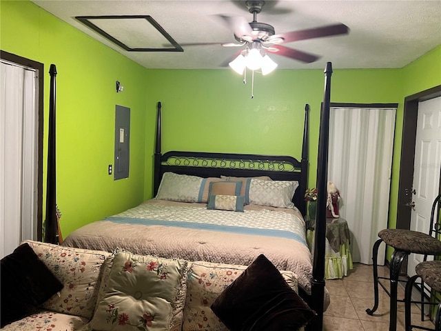 bedroom with ceiling fan, light tile patterned floors, and electric panel