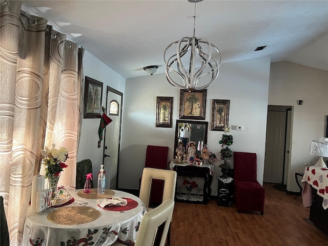 dining space featuring hardwood / wood-style floors, lofted ceiling, and a notable chandelier