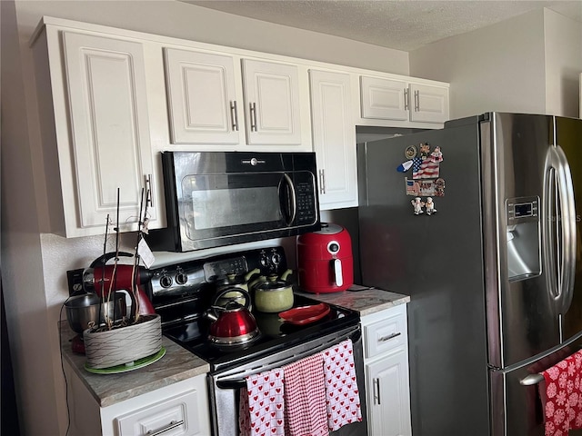 kitchen featuring black appliances, white cabinetry, and a textured ceiling