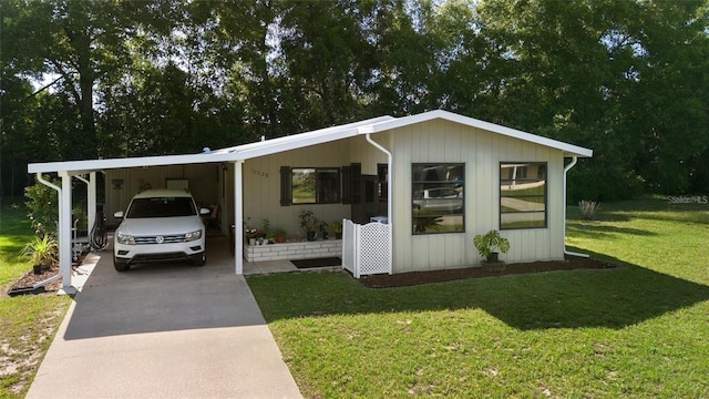 manufactured / mobile home with a front lawn and a carport