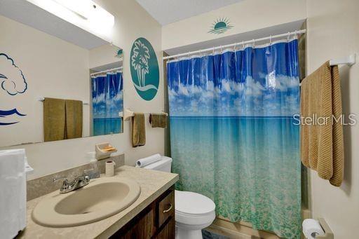 full bathroom featuring vanity, toilet, and shower / bath combination with curtain