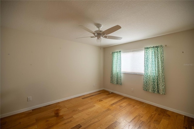 spare room with a textured ceiling, light hardwood / wood-style flooring, and ceiling fan