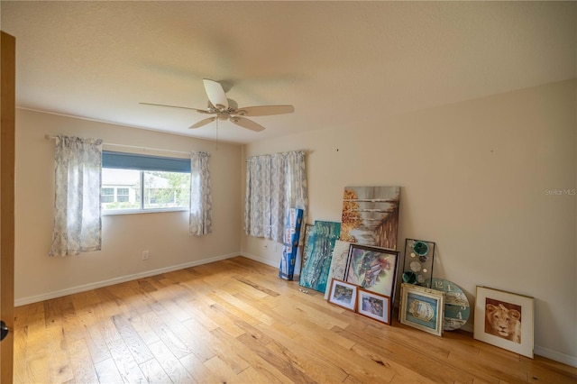 empty room with a textured ceiling, ceiling fan, and light hardwood / wood-style floors