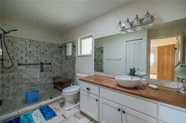 bathroom with toilet, a shower with door, and vanity