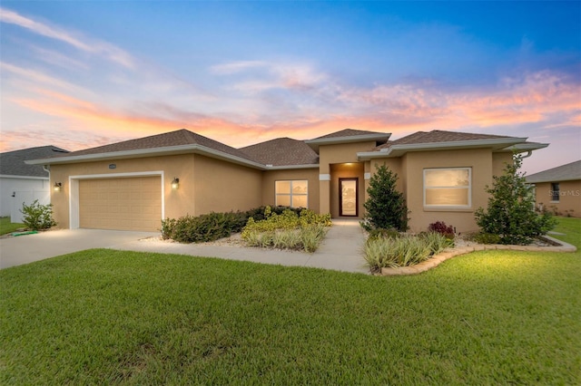 prairie-style house with a garage and a yard