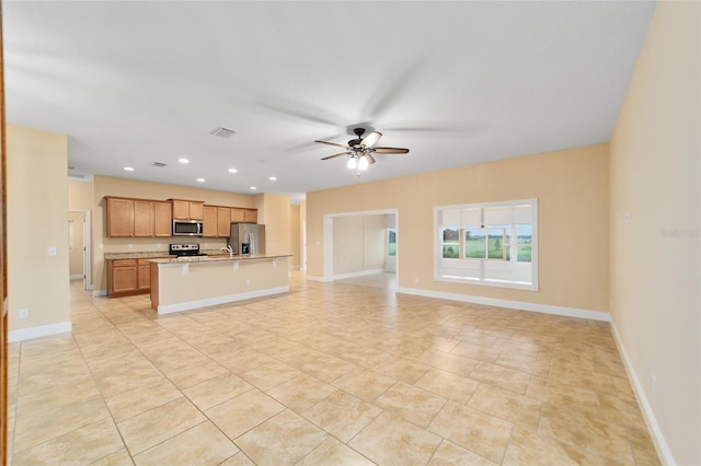 unfurnished living room featuring ceiling fan and light tile patterned floors