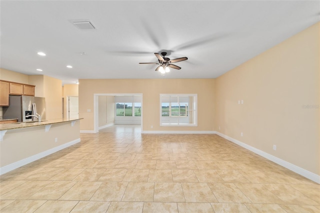 unfurnished living room featuring ceiling fan