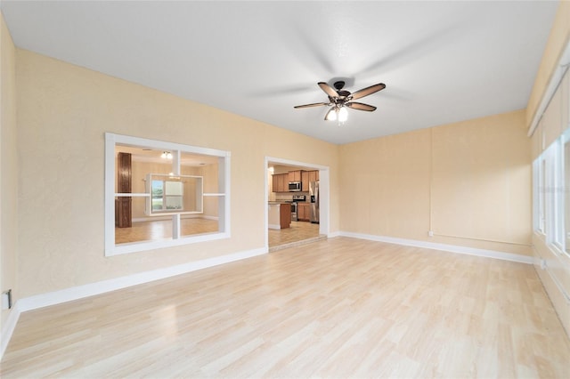 empty room with light hardwood / wood-style flooring and ceiling fan