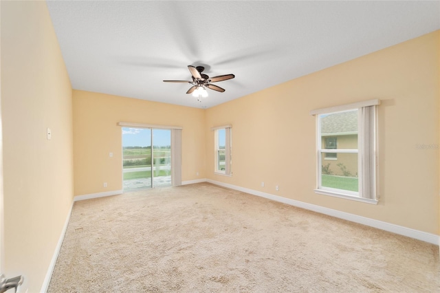 empty room featuring ceiling fan and light colored carpet