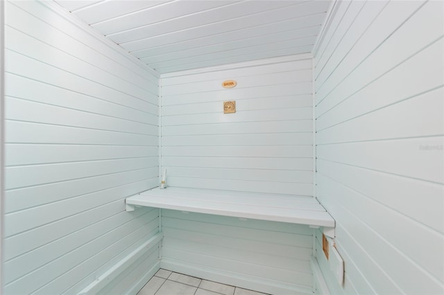 view of sauna featuring wood walls and tile patterned flooring