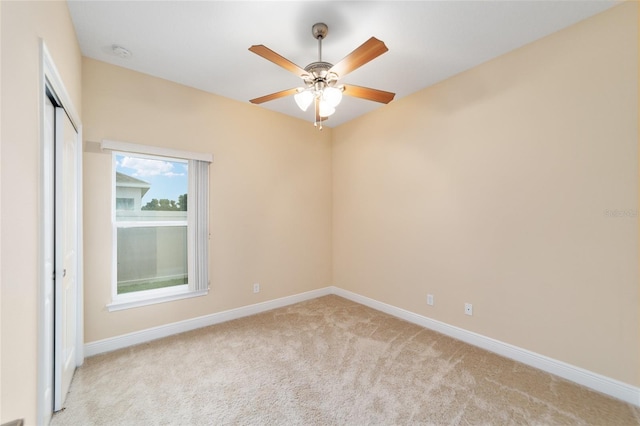 empty room featuring light colored carpet and ceiling fan