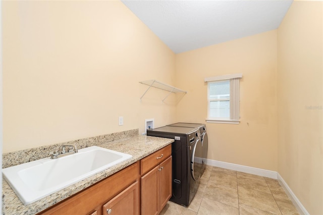 clothes washing area featuring light tile patterned floors, cabinets, independent washer and dryer, and sink