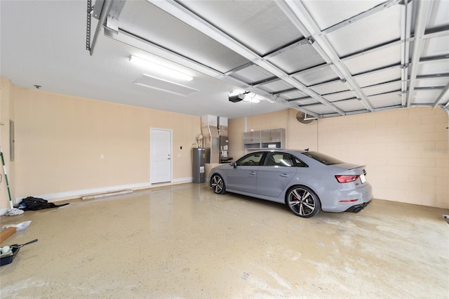 garage with a garage door opener, heating unit, and water heater