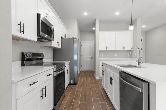 kitchen featuring pendant lighting, sink, white cabinetry, and stainless steel appliances