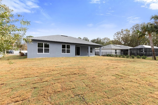 rear view of property featuring a lawn