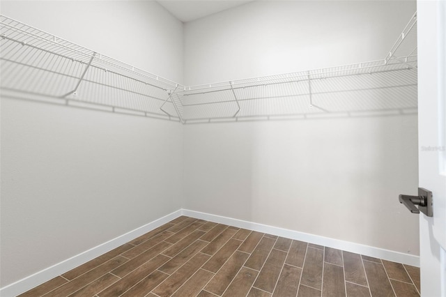 spacious closet featuring dark hardwood / wood-style floors