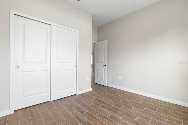 unfurnished bedroom featuring a closet and dark wood-type flooring