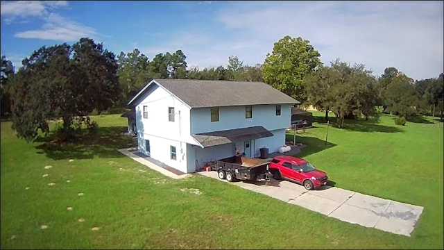 rear view of property featuring a lawn