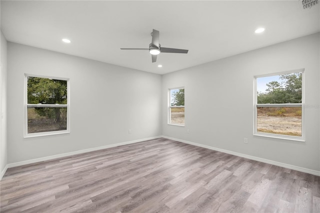 empty room with recessed lighting, light wood-type flooring, and baseboards