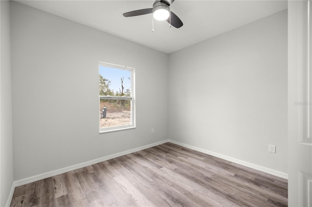 unfurnished room with a ceiling fan, light wood-style flooring, and baseboards