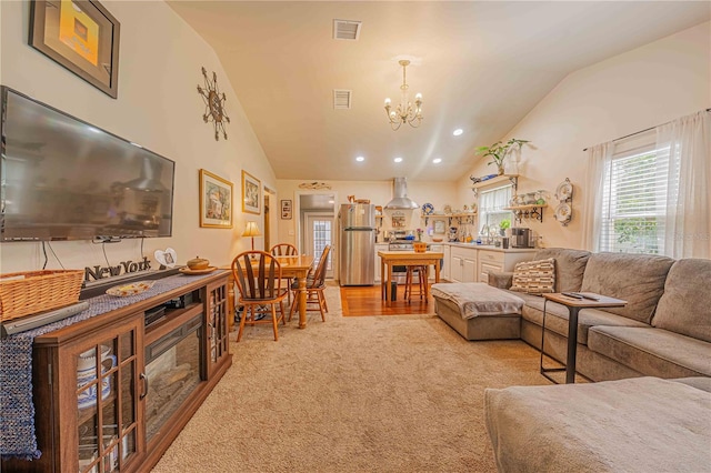 carpeted living room with lofted ceiling and a chandelier